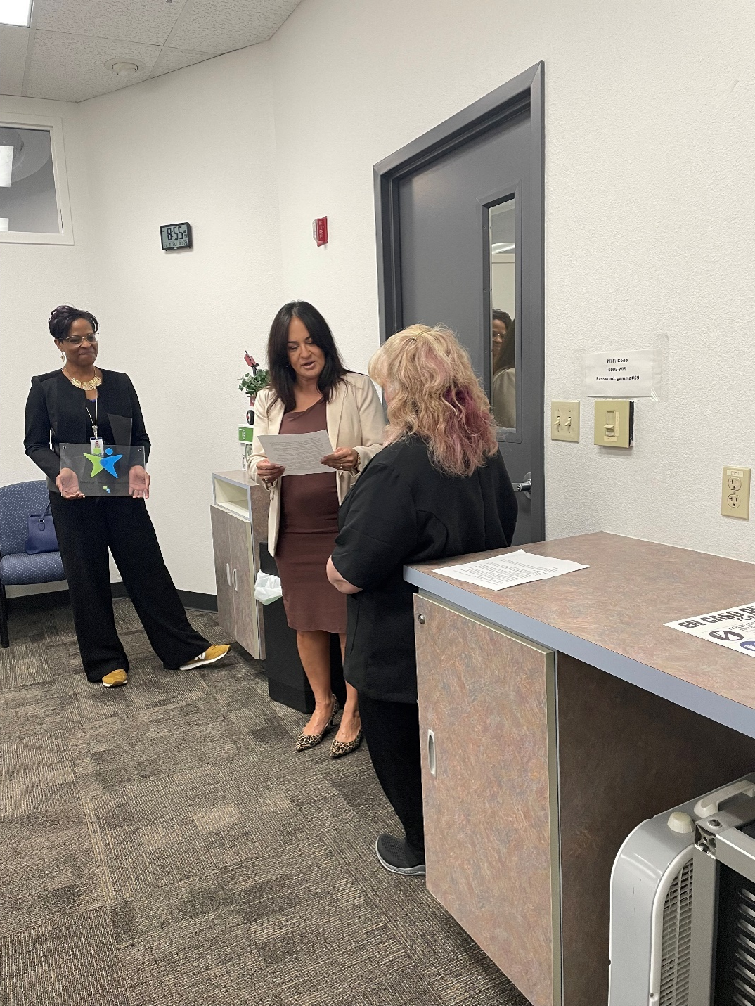 a clark county school district manager recieves their plaque from a vocational rehabilitation representative