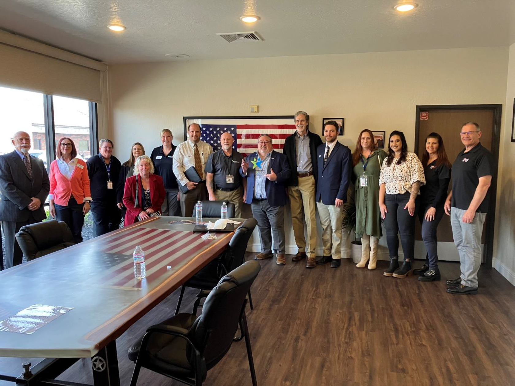 a diverse group of north bay industries management smile as they pose with vocational rehabilitation representatives and their plaque